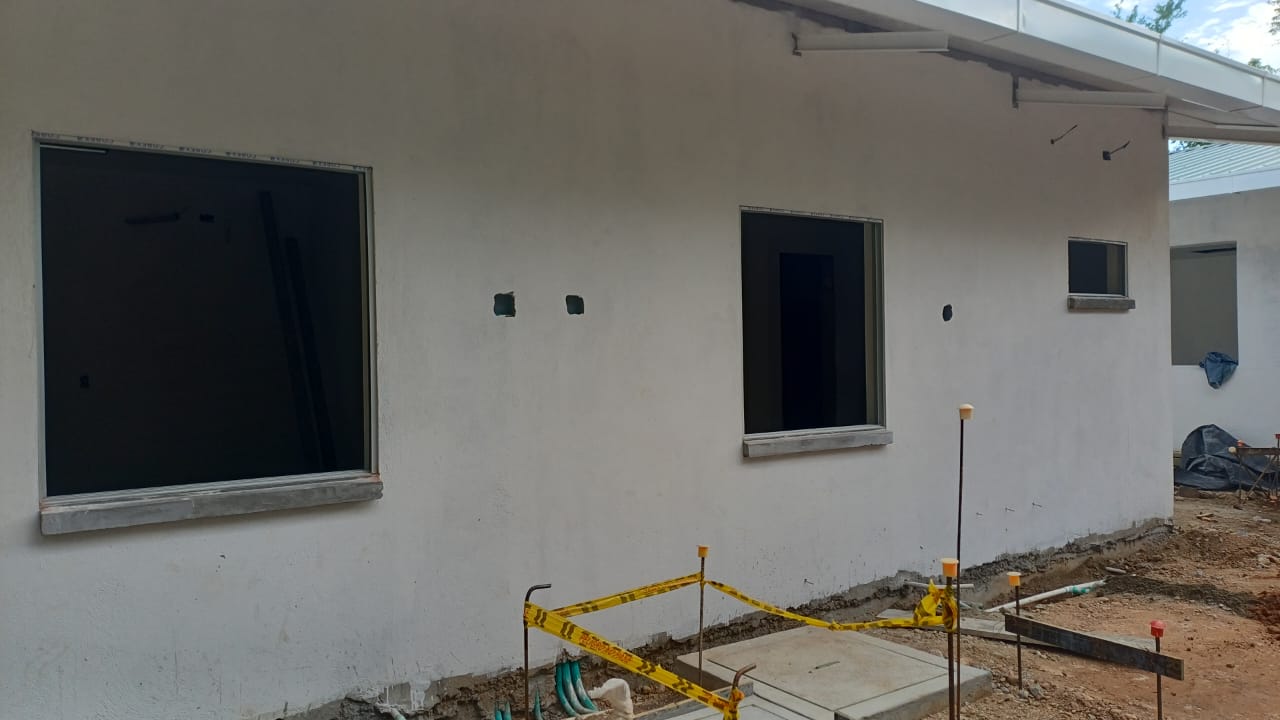 Fachada de edificacion en construccion con ventaneria y cinta de seguridad